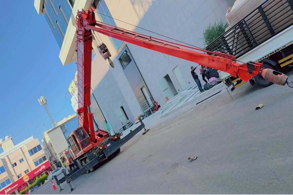 ذراع كرين أحمر بجوار مبنى قيد الإنشاء