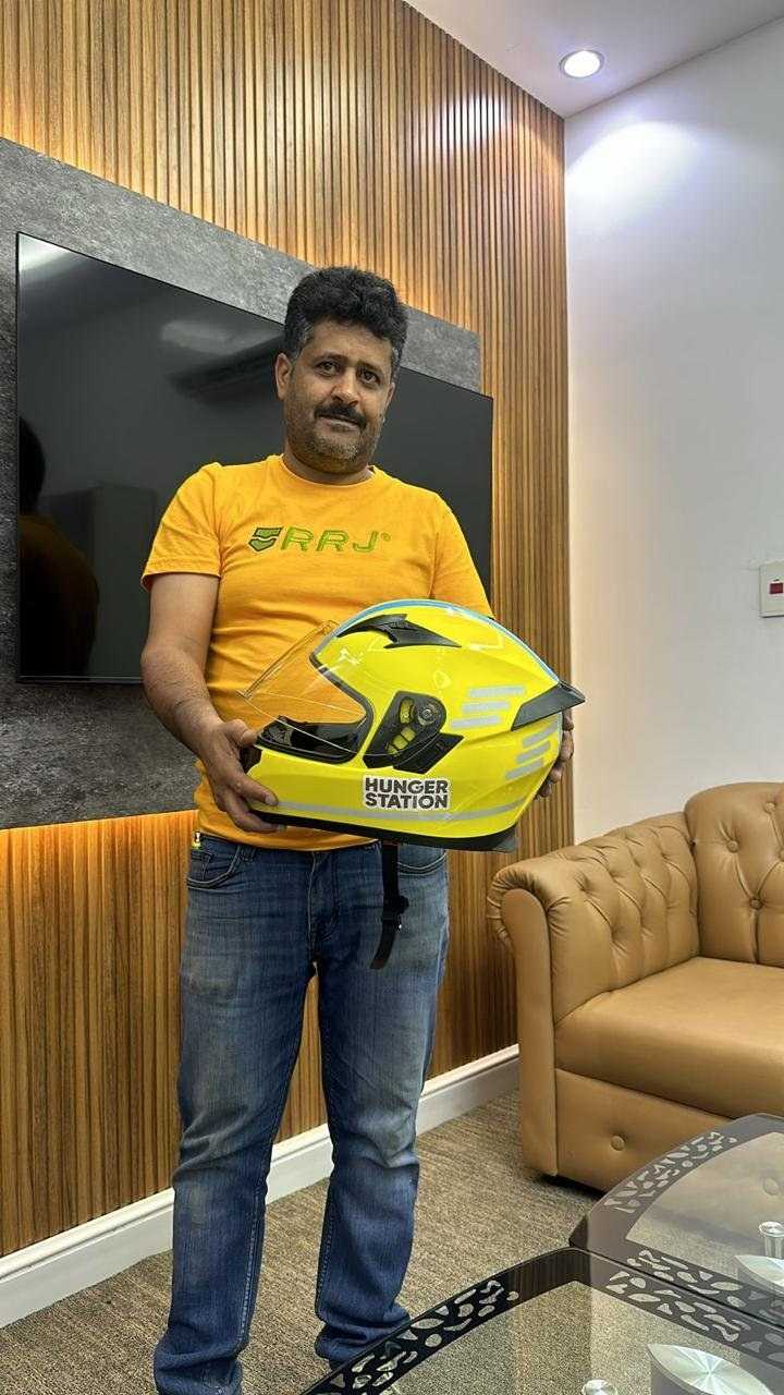 ہنگر اسٹیشن کا ڈیلیوری ہیلمٹ تھامے ایک شخص