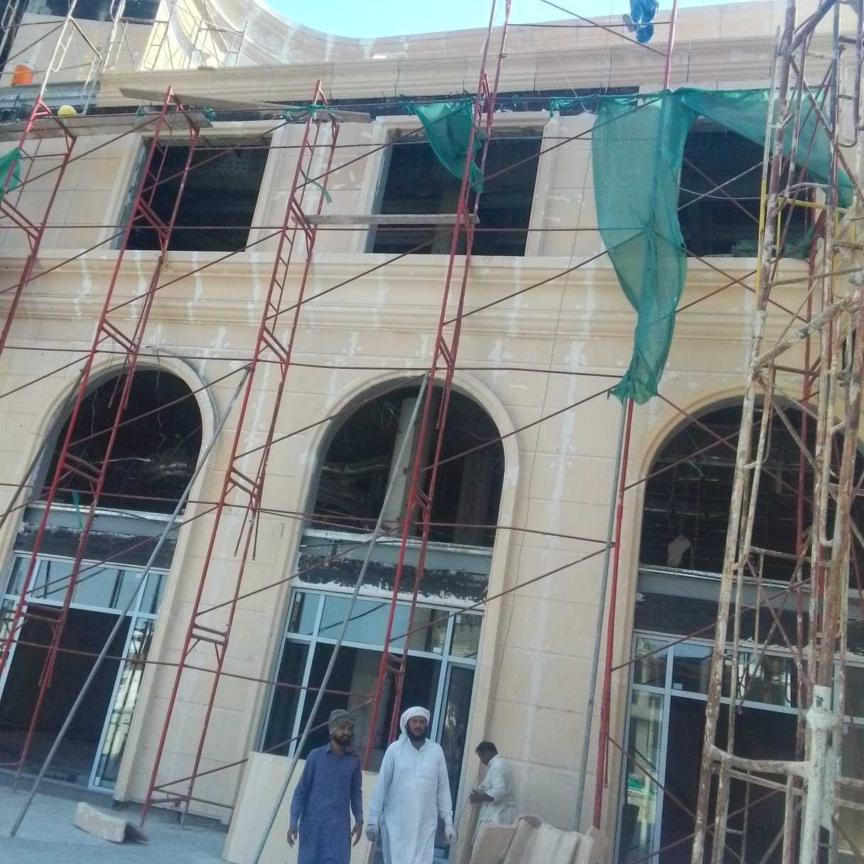 واجهة بأقواس قيد التشطيب خلف السقالات